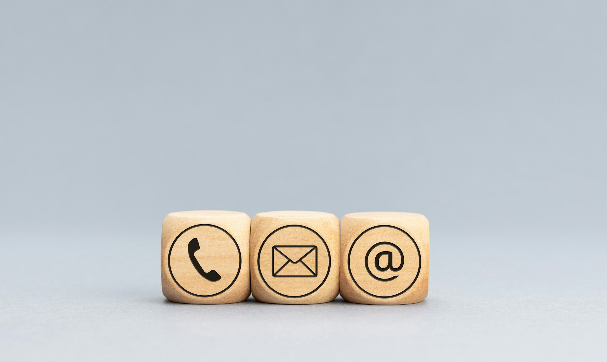 Contact icons on wooden blocks on gray background